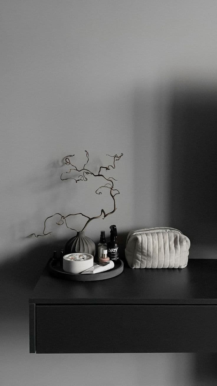 Dark console styled with a sculptural branch, tray and ceramics